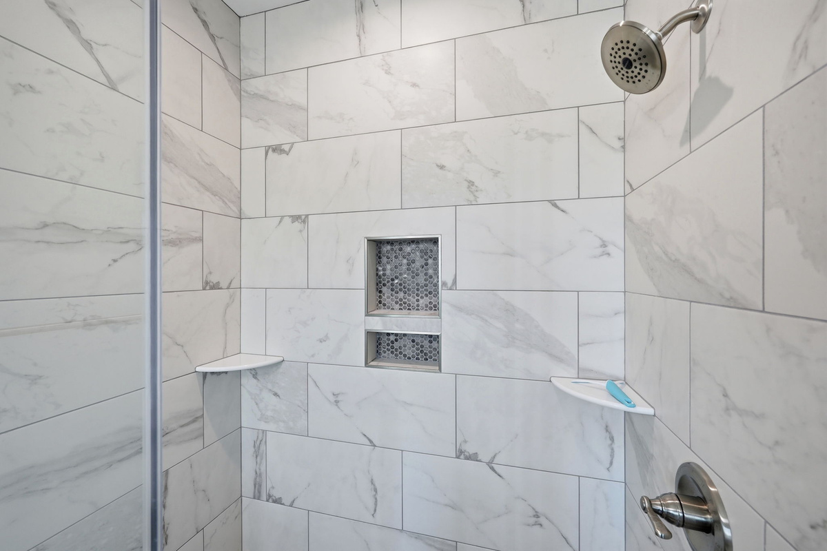 Refresh in the beautifully tiled walk-in shower after a day at the beach