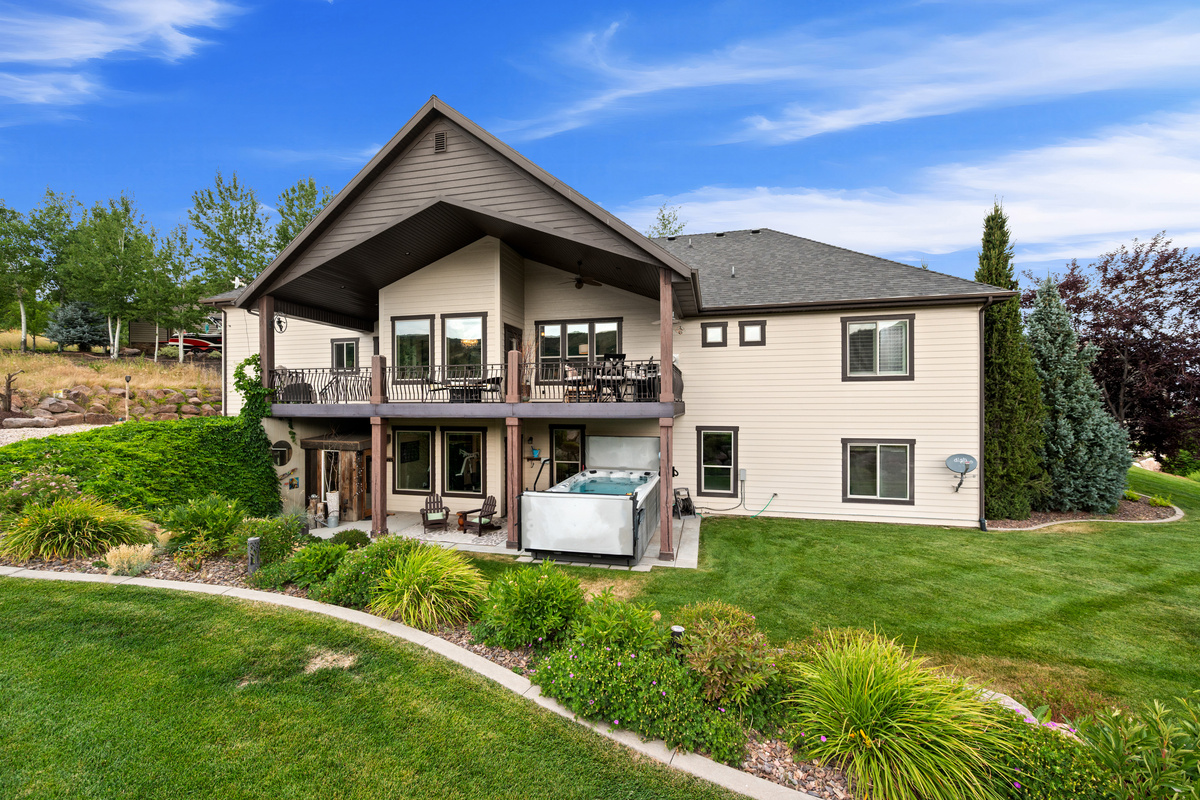 Spacious backyard retreat featuring multiple outdoor living areas, a covered patio, swim spa, and beautifully landscaped grounds. A walking path alongside the home.