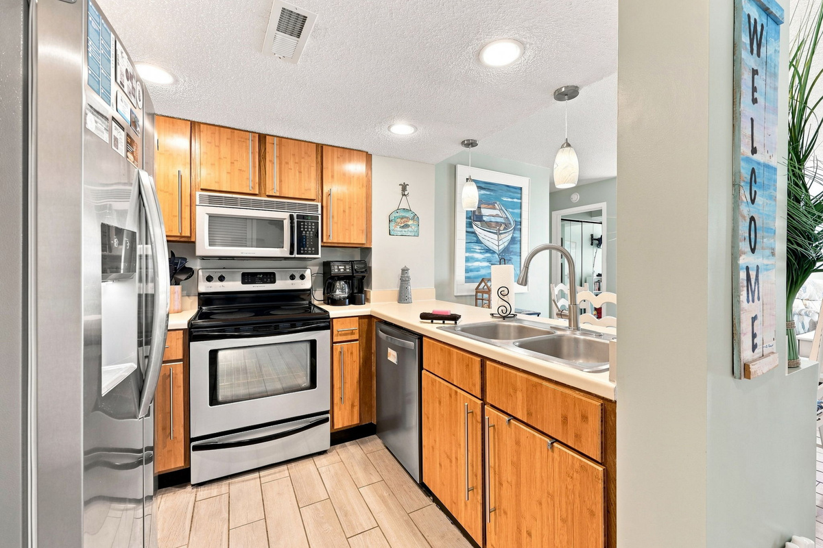 Clean, fully stocked kitchen featuring stainless steel appliances and ample counter space.