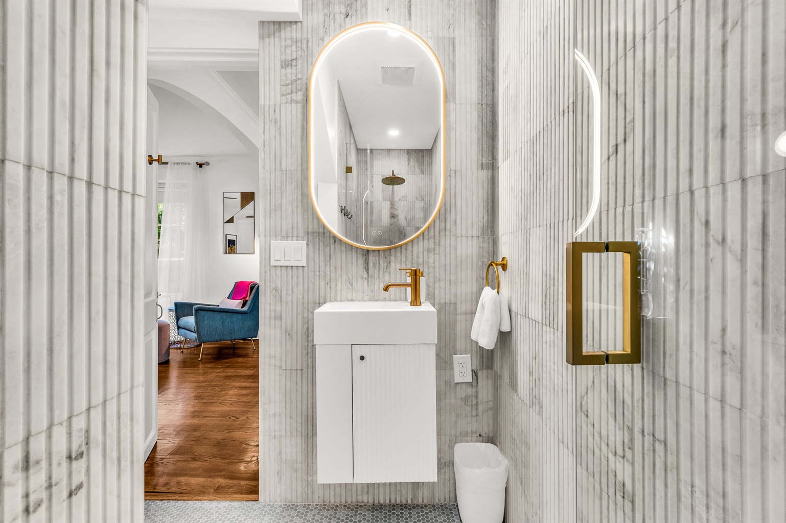 Full Bathroom #3: Discreetly located off the dining room, this newly built guest bathroom showcases floor-to-ceiling fluted marble, a spa-inspired shower, floating vanity, and an elegant make-up bar for a true resort feel.
