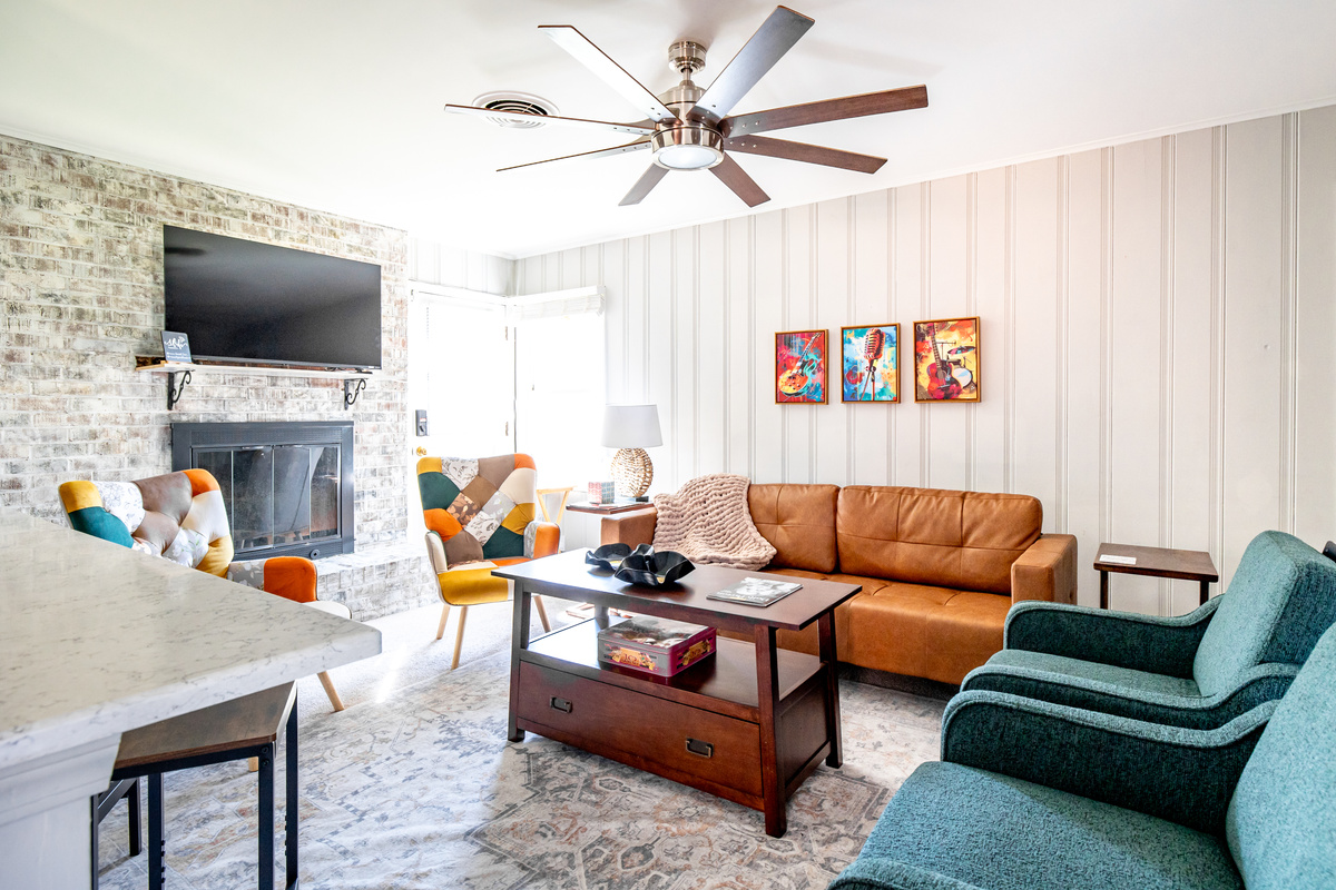 Living room that opens to the kitchen. Plenty of seating, decorative fireplace, TV