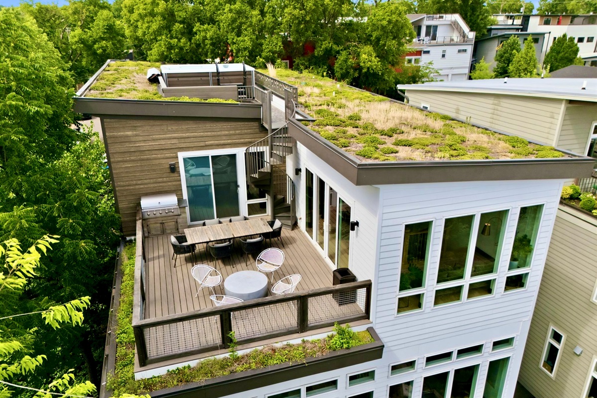 Aerial view of the home's rooftop terrace w/ seating nestled among a canopy of trees.

