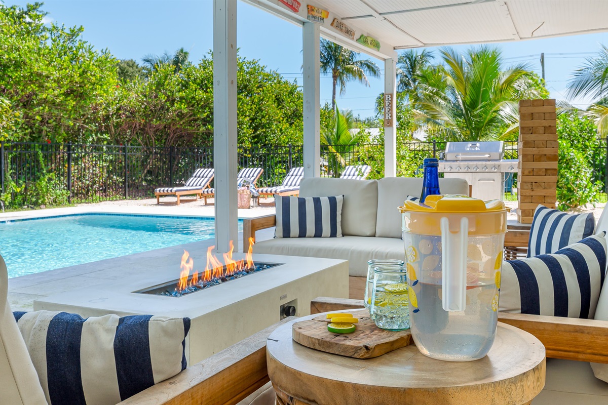 The pool deck is finished in shell white limestone, offering a beautiful natural backdrop.  By night, enjoy the tiki bar, TV, fire table, and the glow of the Jupiter Lighthouse Beacon.