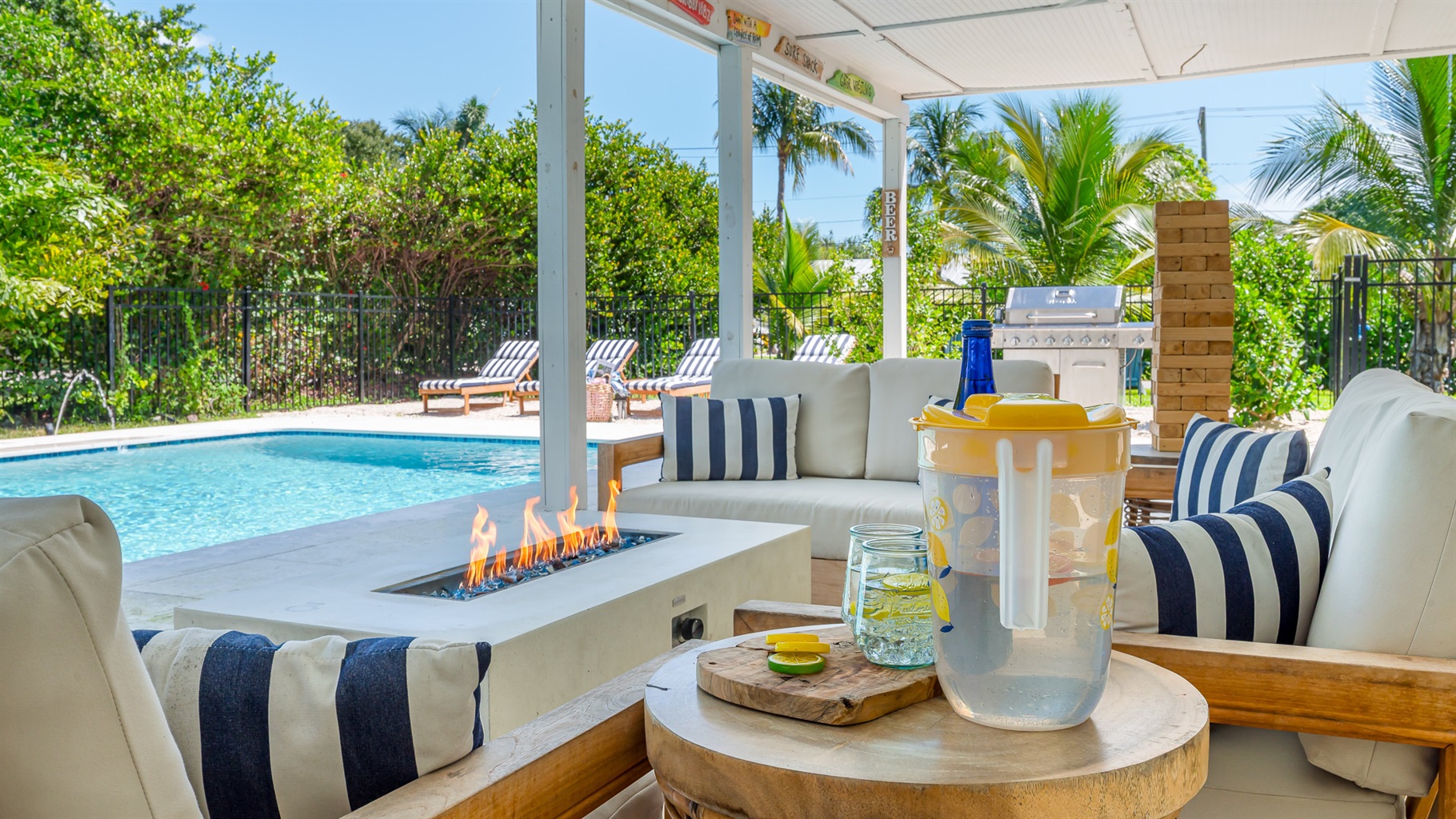 The pool deck is finished in shell white limestone, offering a beautiful natural backdrop.  By night, enjoy the tiki bar, TV, fire table, and the glow of the Jupiter Lighthouse Beacon.