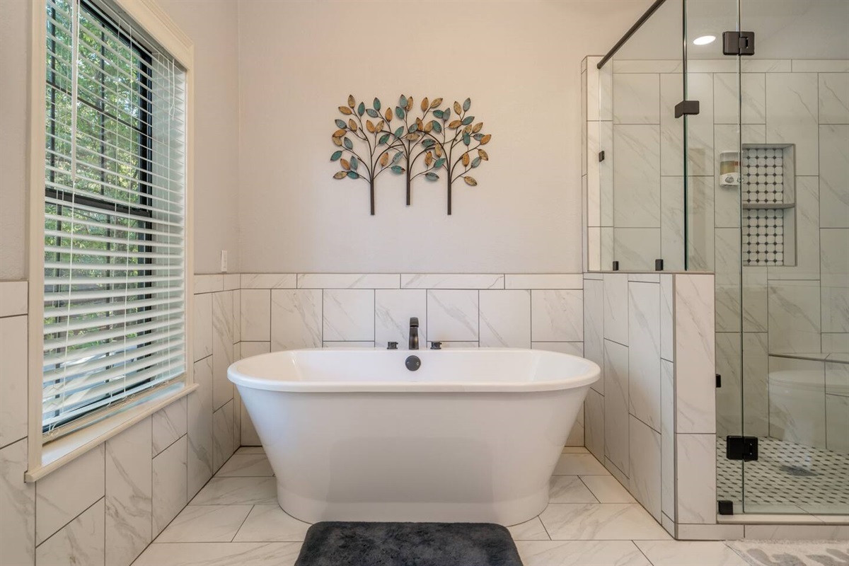 Relax in this amazing soaking tub or clean up quick in a beautifully tiled shower. We provide shampoo, body wash and nice soft towels. - Master Bathroom. 