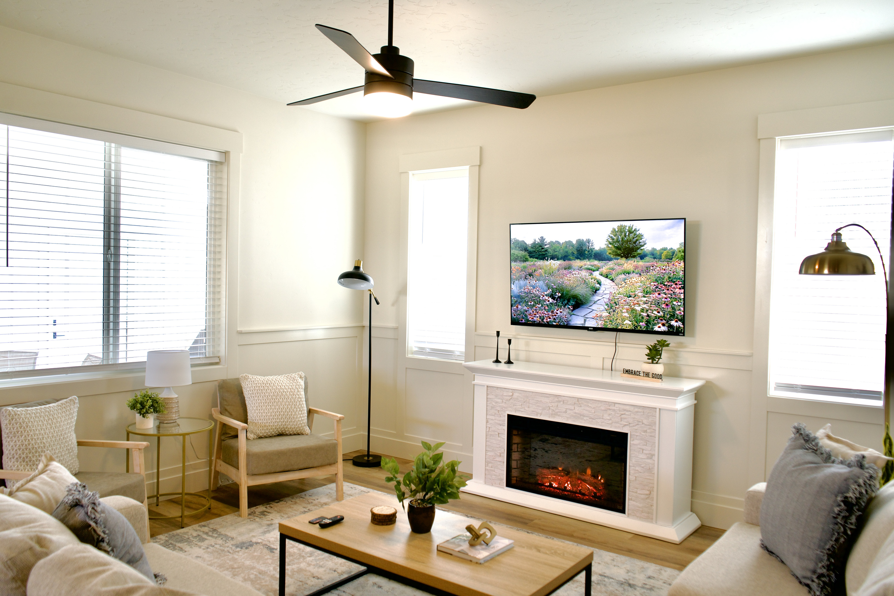Enjoy the beautifully designed open-concept downstairs living room, featuring comfortable seating, a gas fireplace, and a Smart TV for a relaxing and inviting entertainment space.
