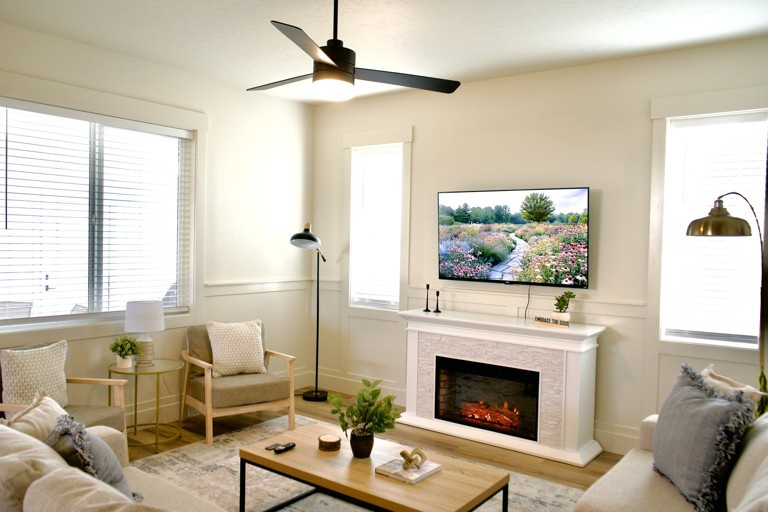 Enjoy the beautifully designed open-concept downstairs living room, featuring comfortable seating, a gas fireplace, and a Smart TV for a relaxing and inviting entertainment space.