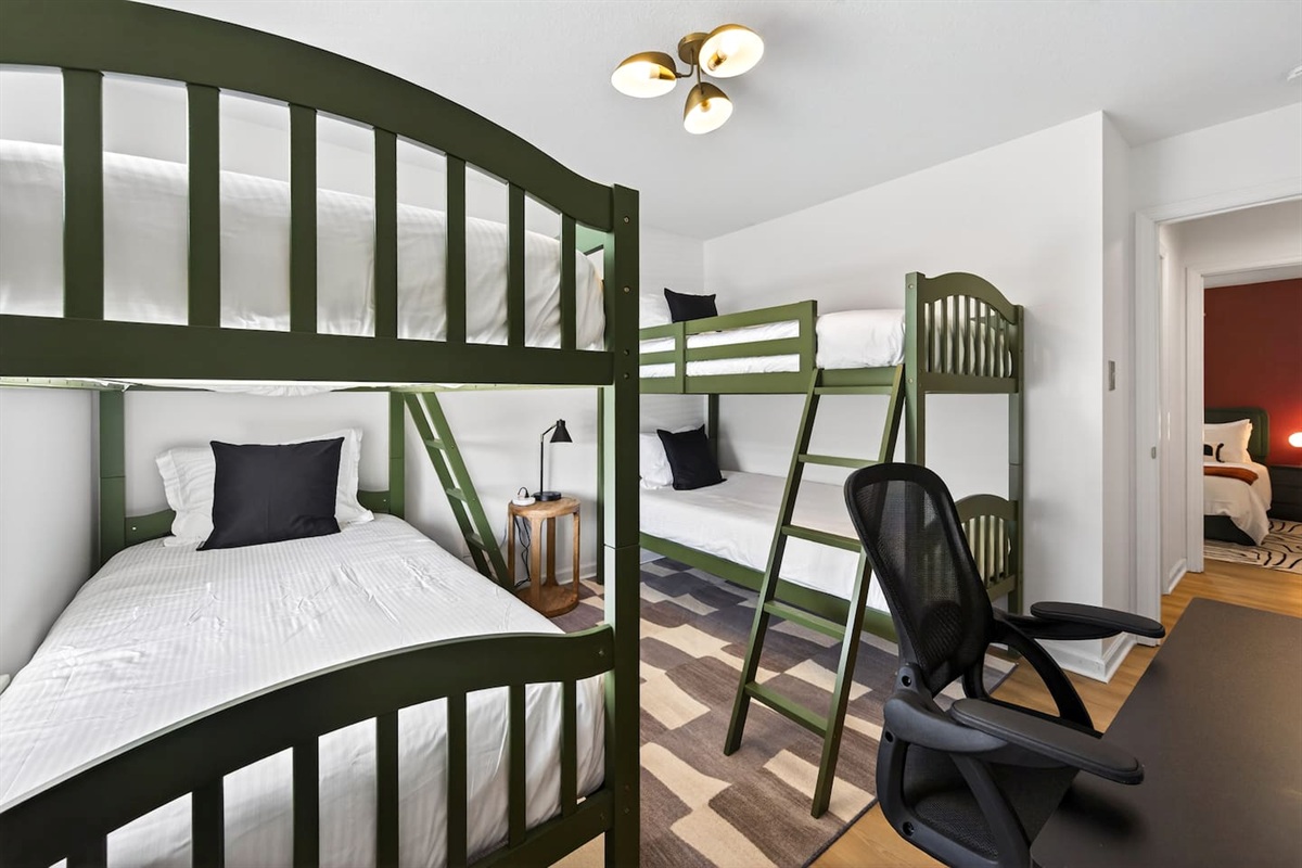 Bunk bedroom with 4 twin beds and a work table +TV