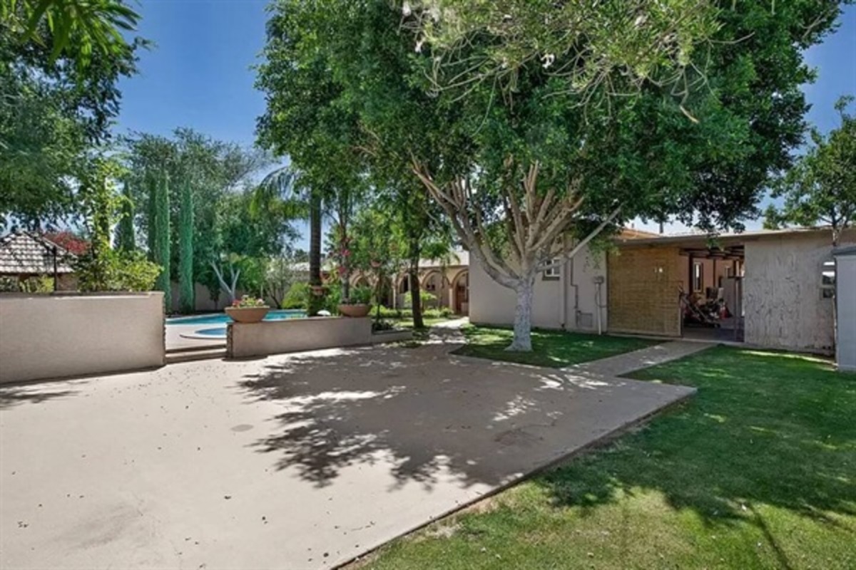 This expansive backyard offers mature trees, open green space, and room to relax, play, or gather under the Arizona sun.