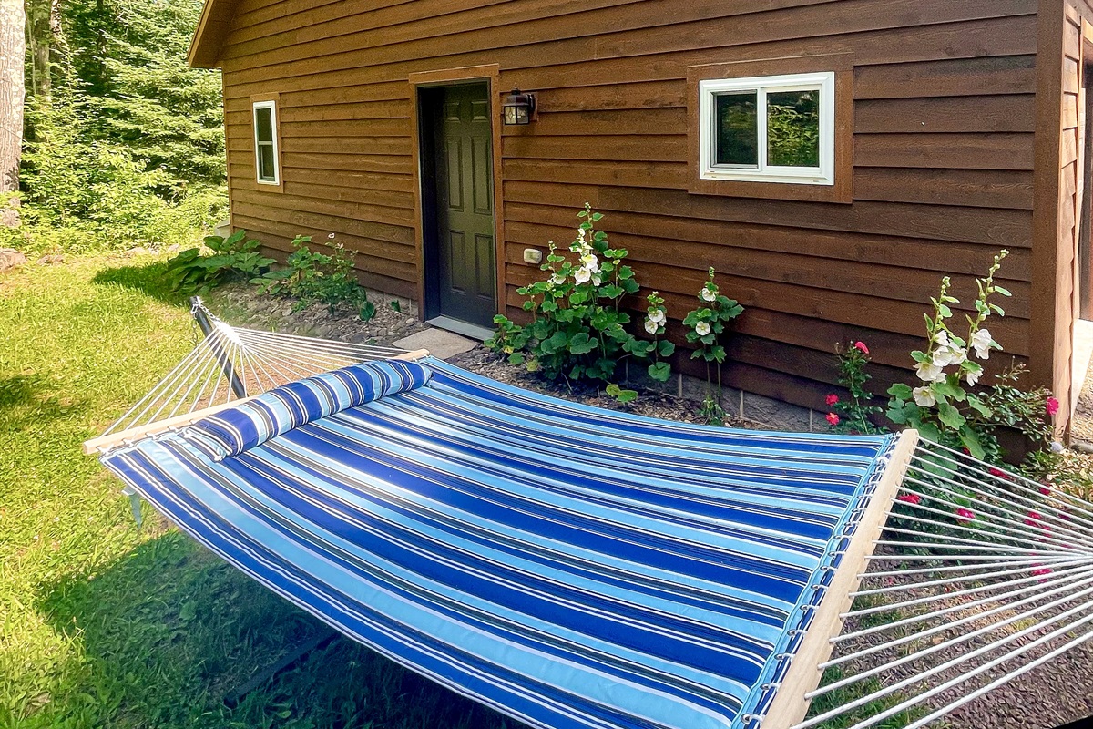 Far side of Rock Garden Cottage with access to grill, a double hammock, and a hill with wooded views. (Seasonal May-Oct)