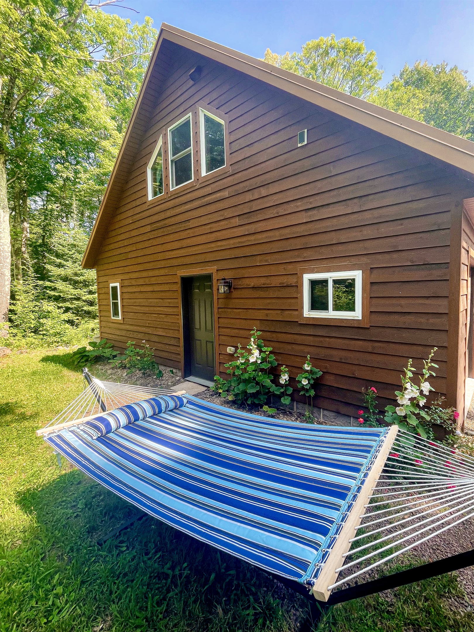 Far side of Rock Garden Cottage with access to grill, a double hammock, and a hill with wooded views. (Seasonal May-Oct)