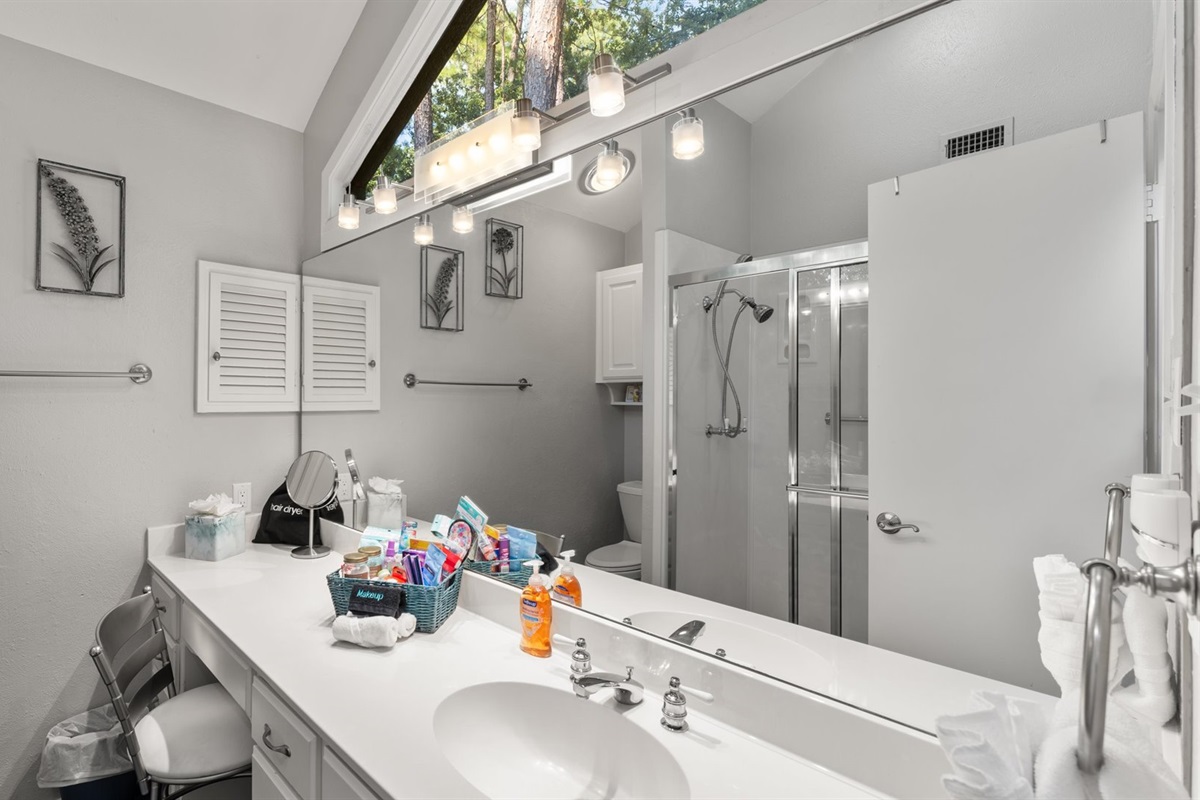 King 2 Bathroom features a walk-in shower, a thoughtful basket filled with essentials, and stunning views through its unique, eye-catching windows.