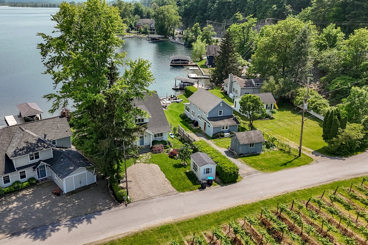 Stunning aerial view of a serene Finger Lakes waterfront retreat, complete with private dock, lush greenery, and charming lakefront homes—perfect for peaceful getaways and water adventures