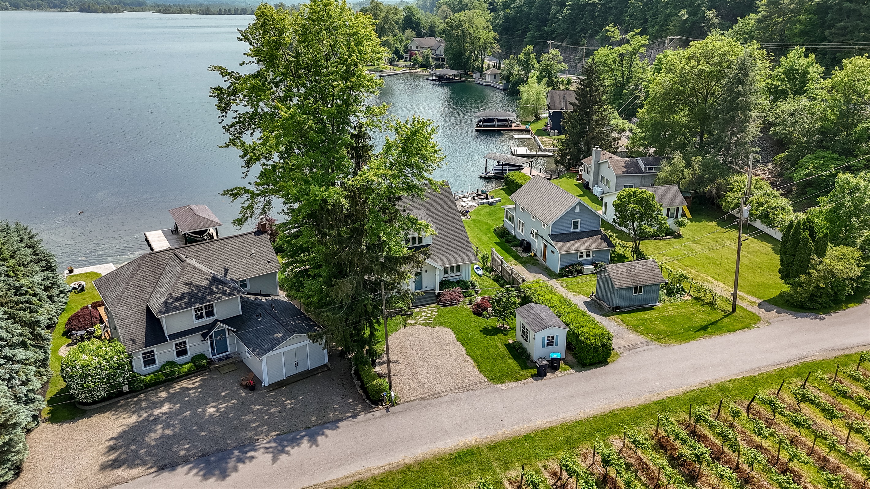 Stunning aerial view of a serene Finger Lakes waterfront retreat, complete with private dock, lush greenery, and charming lakefront homes—perfect for peaceful getaways and water adventures