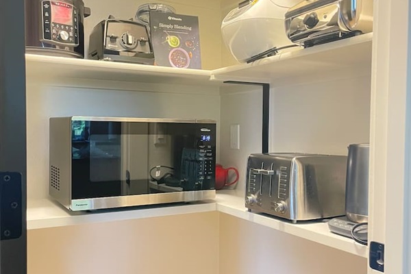 Food pantry with all the kitchen appliances, and step stools.