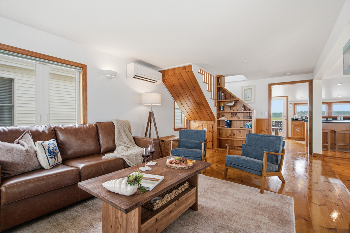 Relax in the open-concept living room with comfortable seating and coastal décor.
