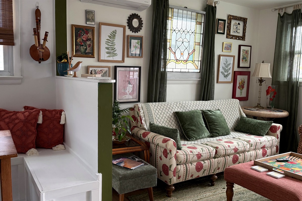 vintage stained glass, bright happy furniture, all mar the living room a comfortable hangout. the collage of prints some new, some vintage are all there to inspire you!