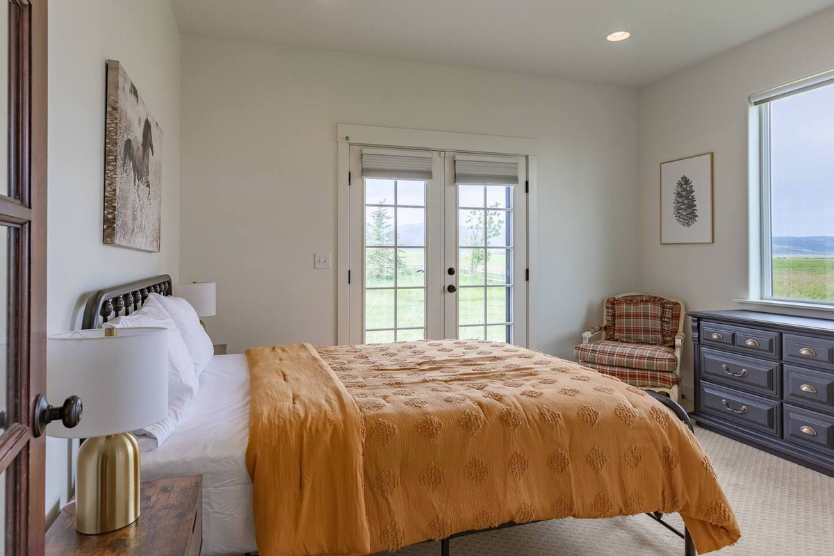 This cozy room includes a queen bed, cushioned chair, and dresser
