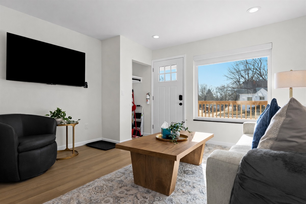 Airy living room with cozy seating, smart TV, and abundant natural light—creating a warm, comfortable space to relax and feel at home.