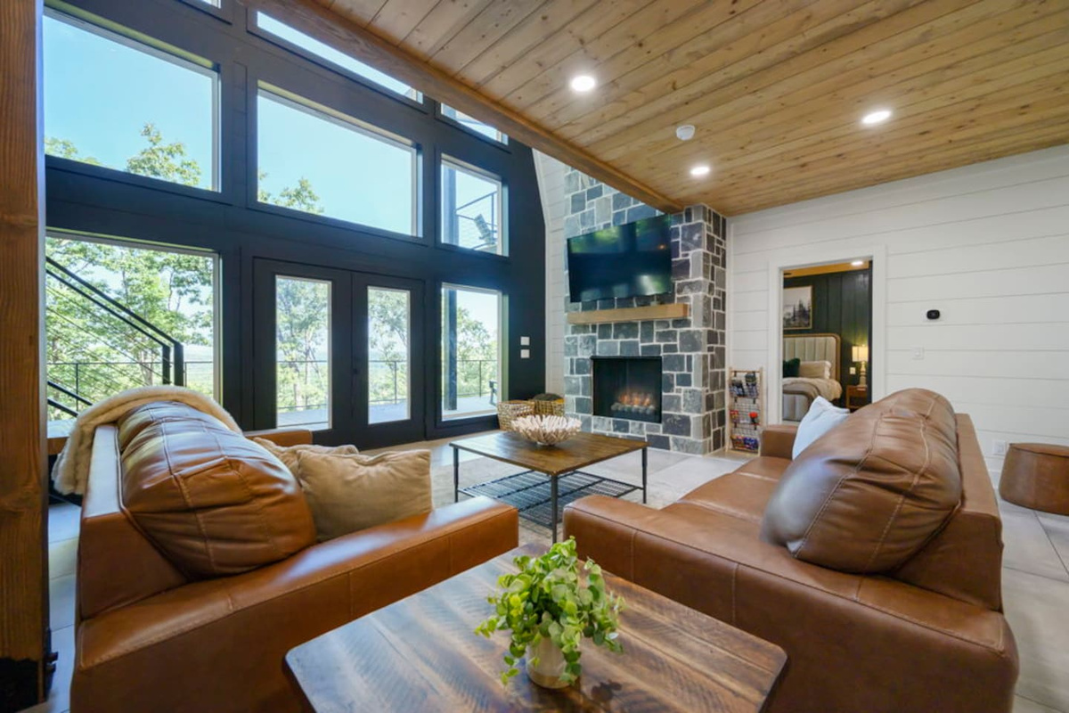 Lower-level living room with large windows overlooking the wooded setting.
