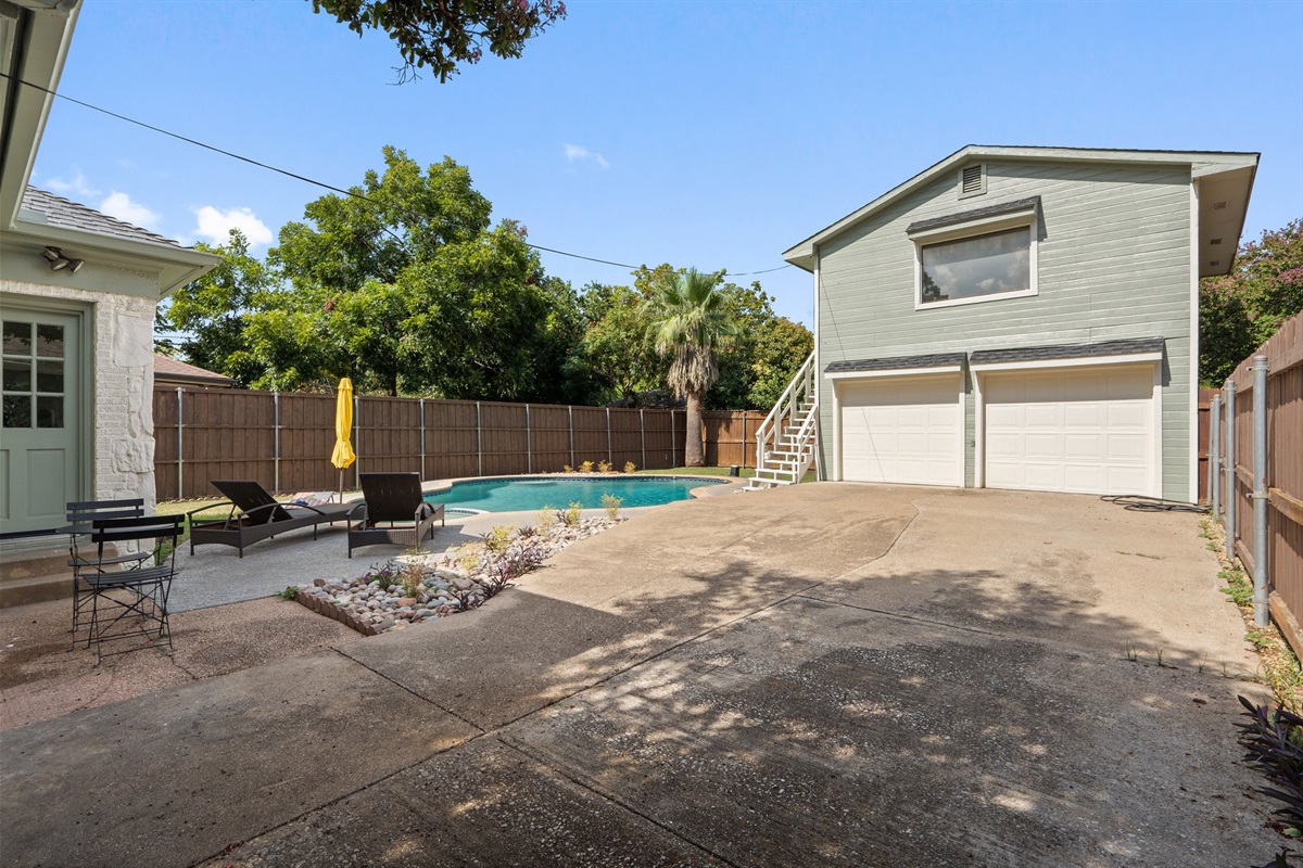 Fully fenced backyard with unheated Pool, sun loungers, outdoor furniture, and patio seating. Detached Studio accessible by exterior stairs. Private outdoor oasis shared between main house and studio guests. Sleeps 10 total.