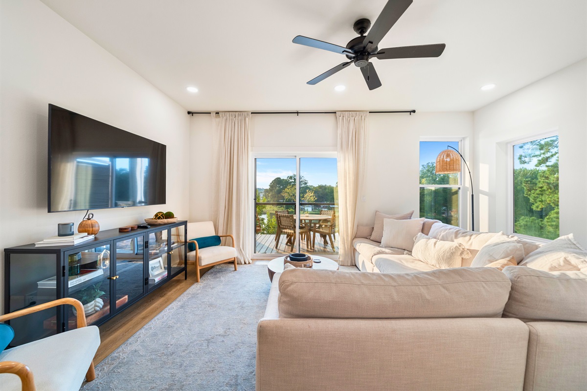 Spacious living room with plush seating and large windows overlooking the lake.