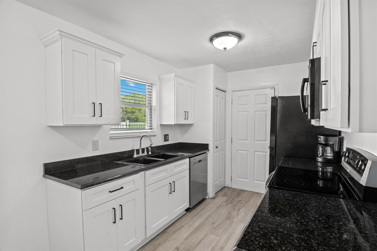 Kitchen. Sink. Door opens to the garage & laundry area.