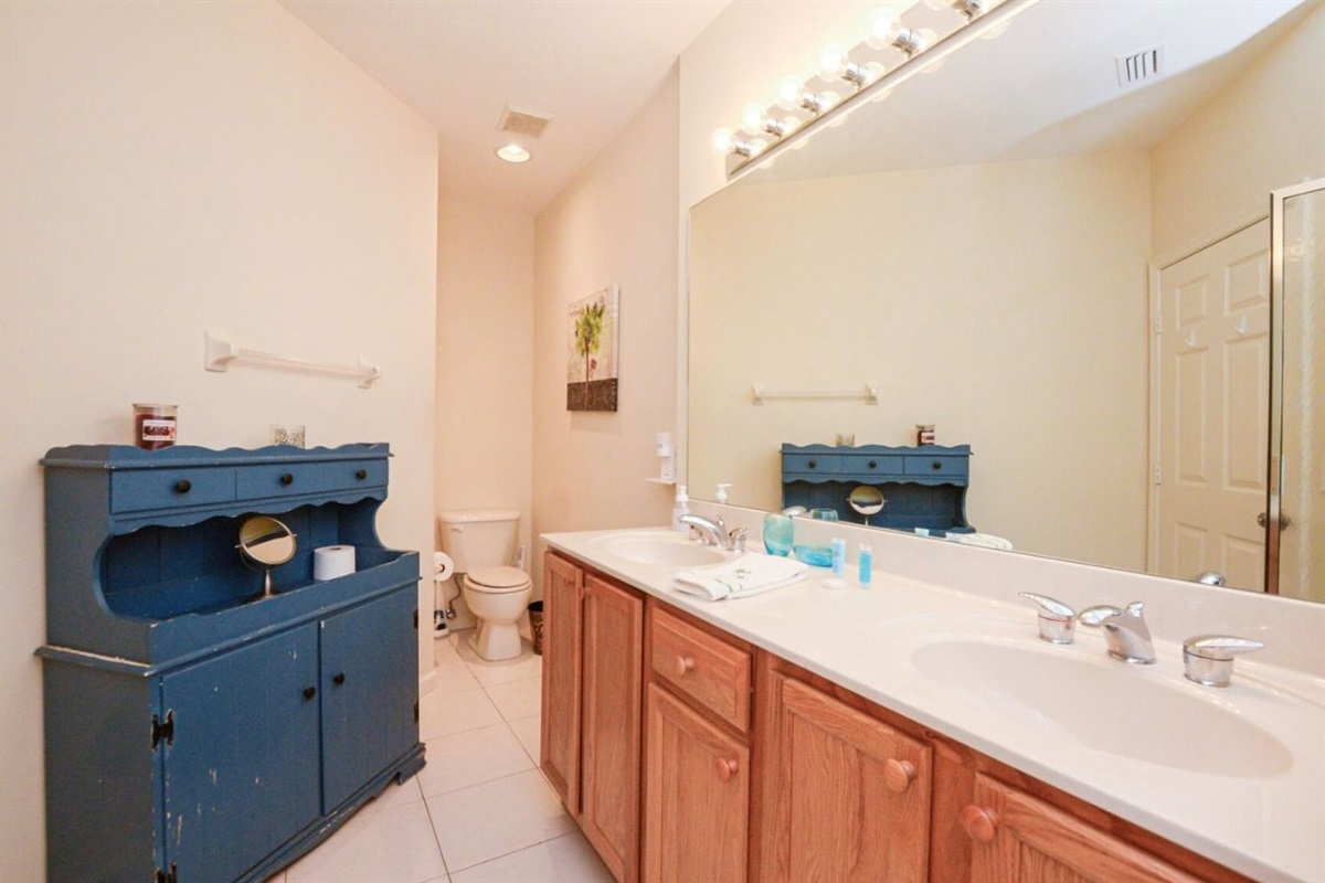 Spacious bathroom with double-sink vanity, tile flooring, and plenty of counter and storage space.
