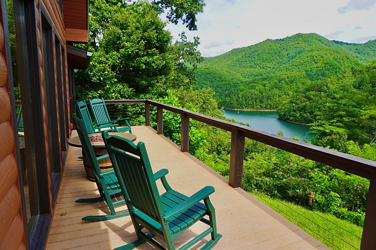 Deck with a View: Relax in rocking chairs overlooking lush mountains and serene waters!