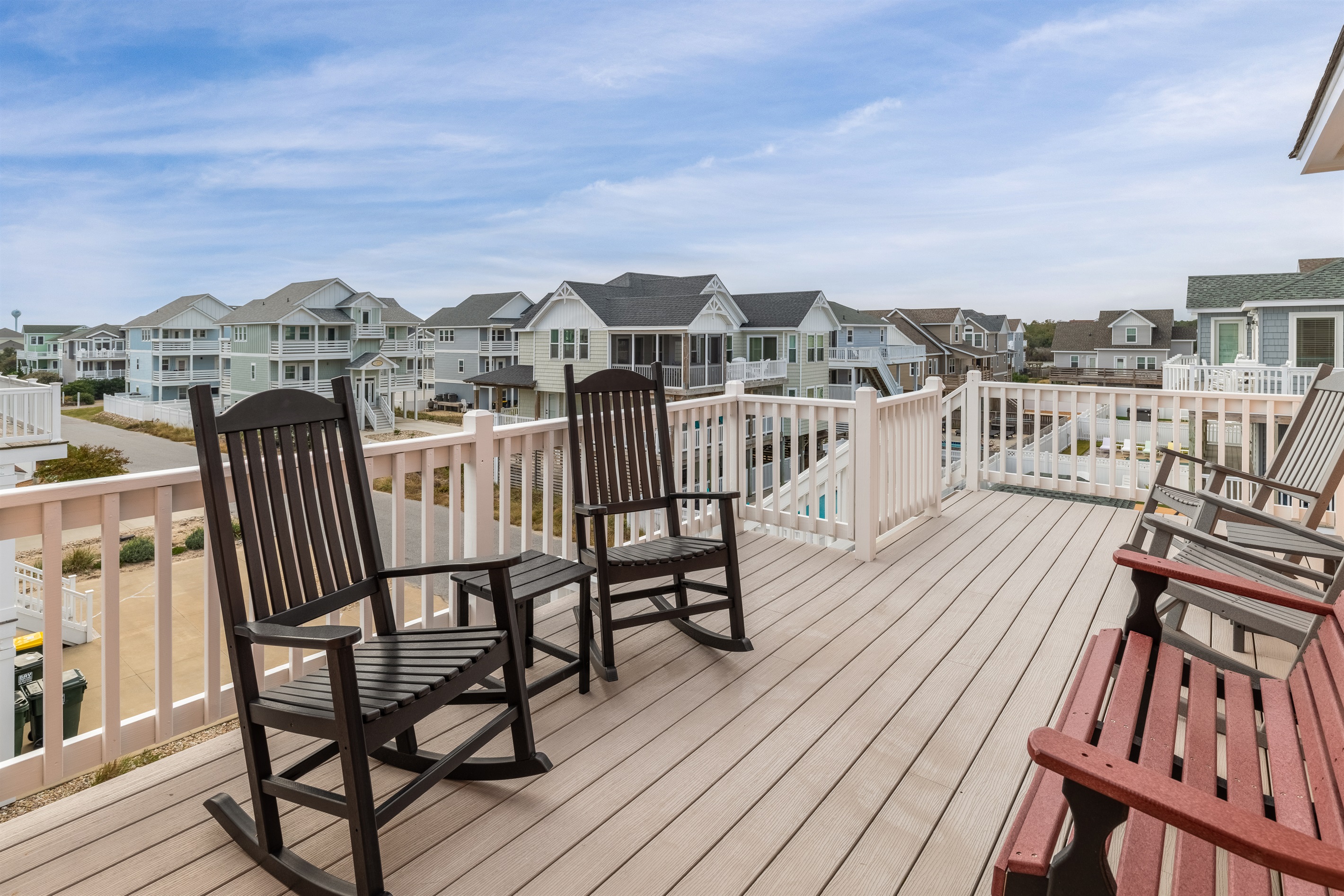 Deck off of kitchen area with stair access to backyard pool area
