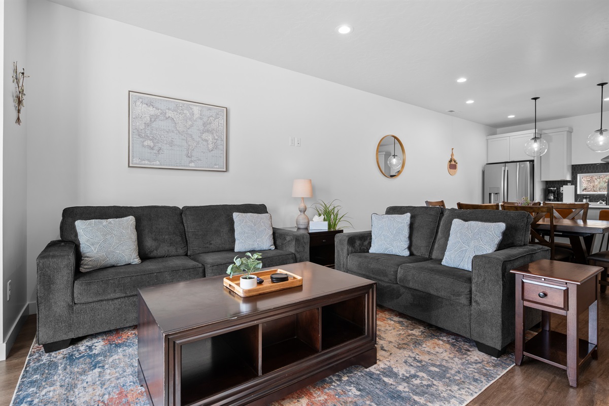 Comfortable living room with large sofa open to kitchen and dining area.