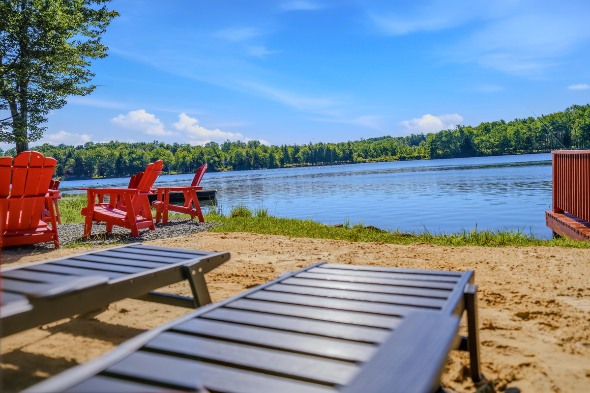Private sandy shoreline with lounge chairs overlooking the open expanse of Lake Carobeth