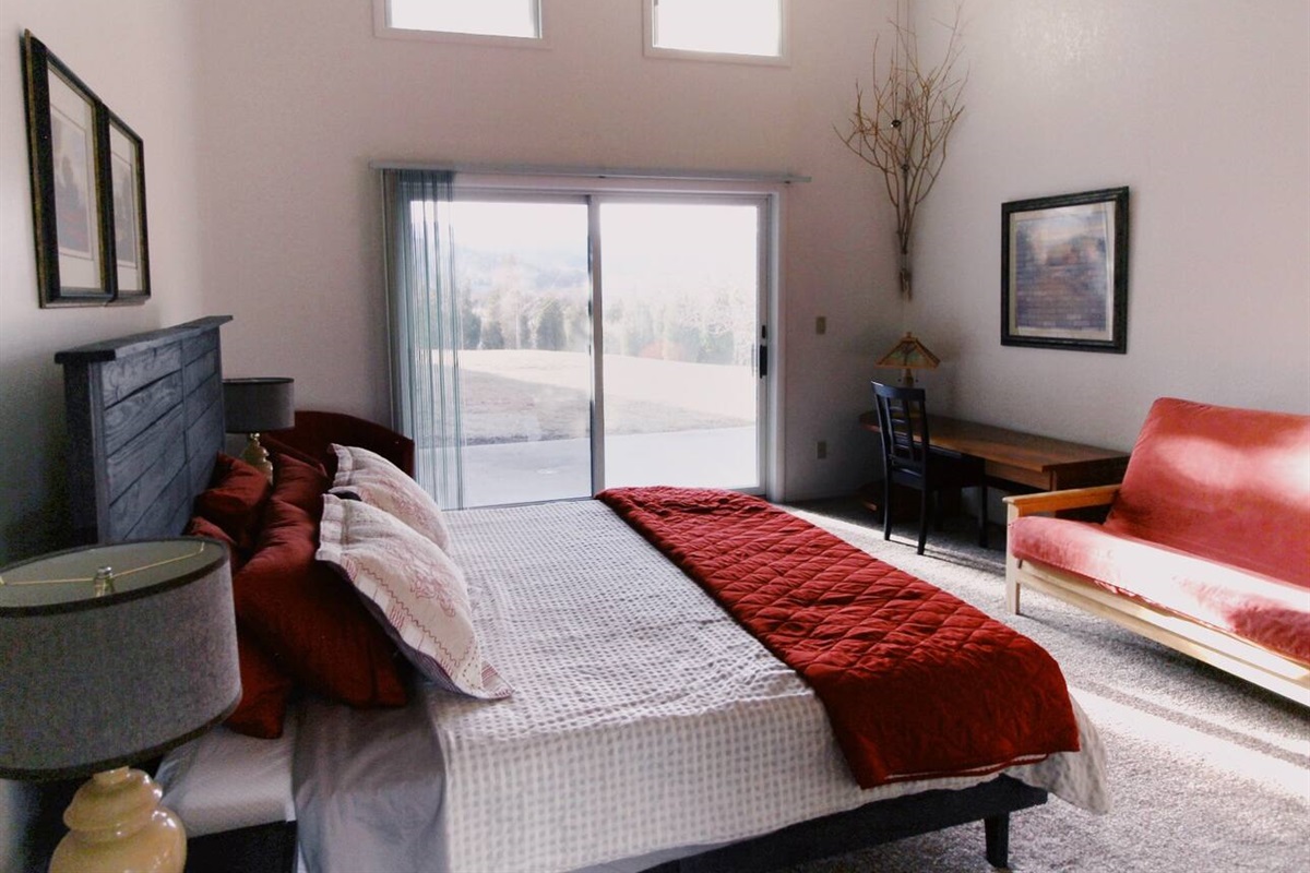 The centerpiece of the room is an exquisite bed. The soft, fresh linens, the perfect blend of colors on the walls and decor, and the glass door offer a seamless connection to the outdoors. 
