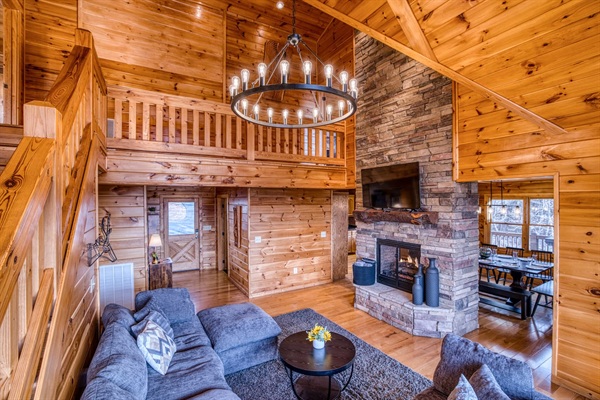Main living room with beautiful A-frame ceiling, wall of windows, double-sided gas fireplace, and stunning mountain views! 