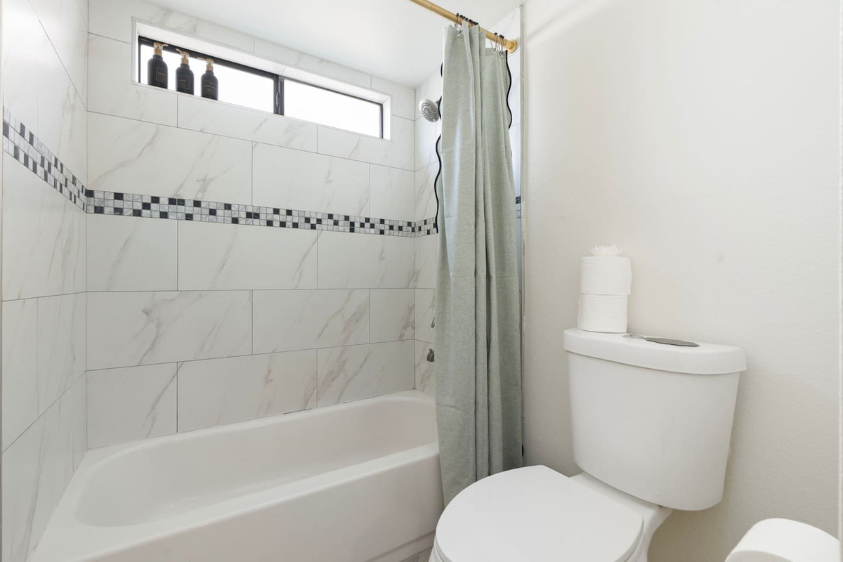 Clean and bright bathroom with marble tile, soaking tub, and skylights—spa-quality spaces designed for comfort and relaxation.