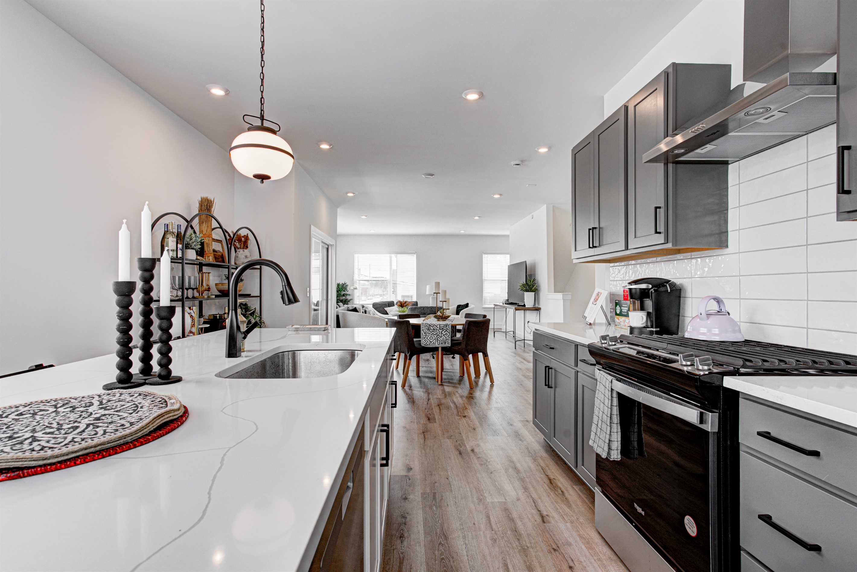 Enjoy a designed open-concept space with a modern kitchen equipped with quartz countertops, stainless steel appliances, and all essentials for home cooking. 