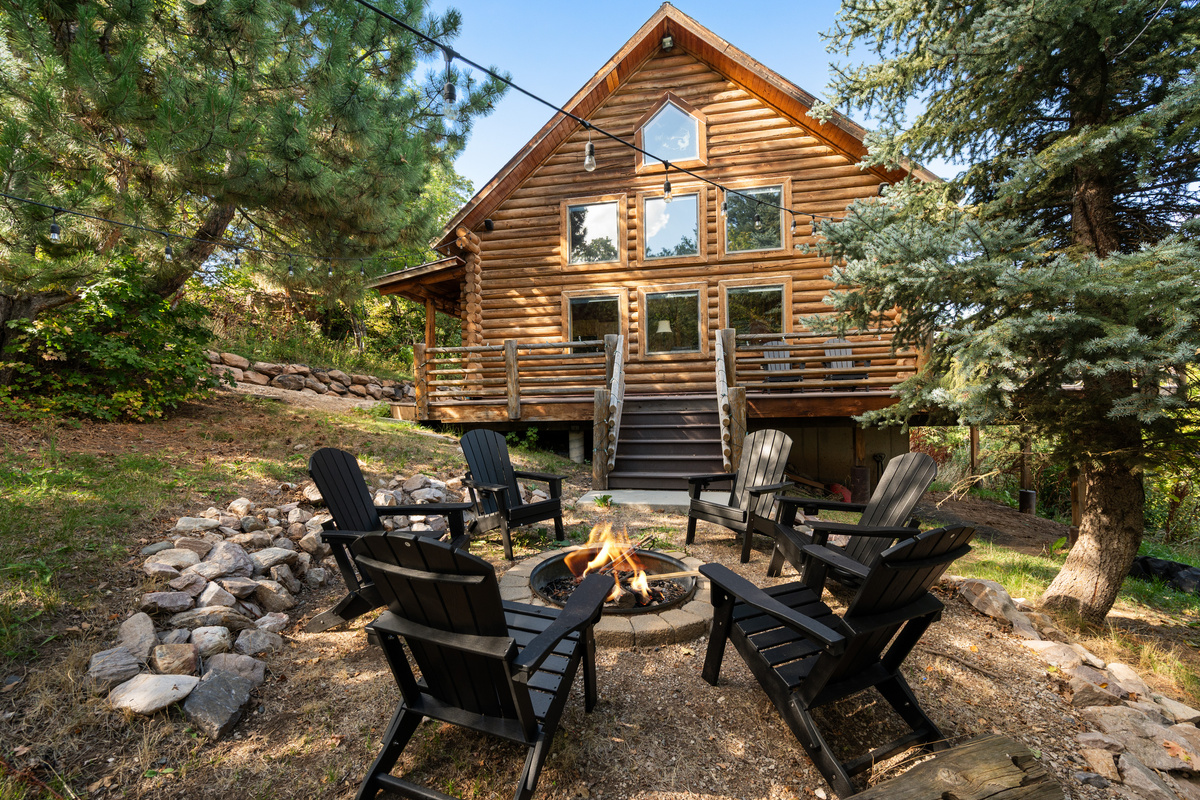 Private outdoor fire pit surrounded by seating beneath the trees.