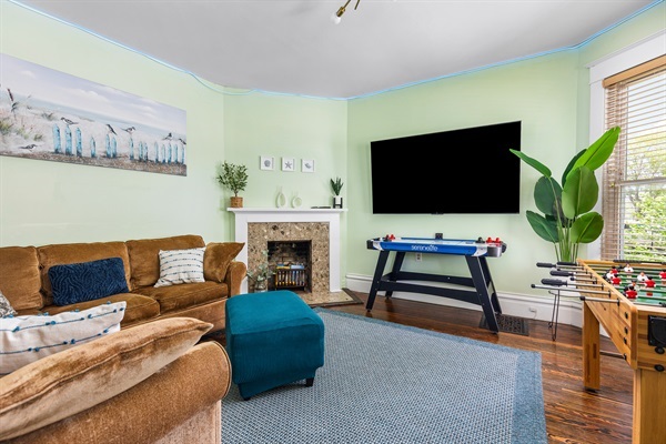 Get comfy in the living room with a plush couch, 75” Smart TV, foosball, and air hockey. Game night is on!