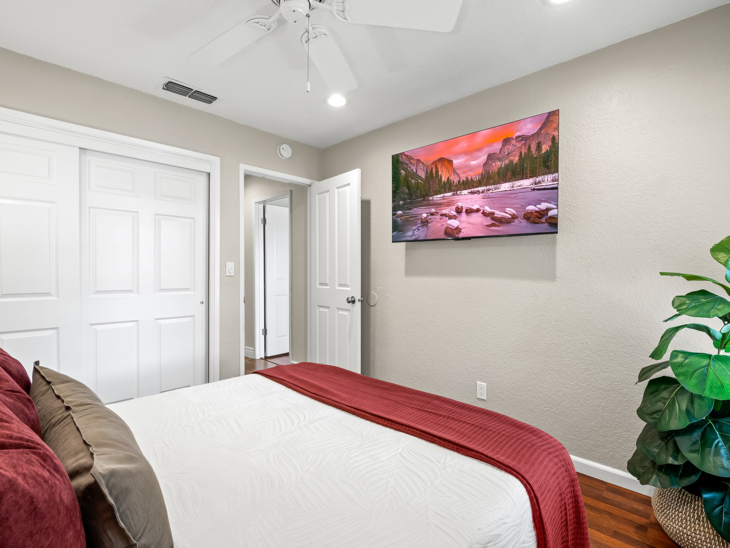 A comfortable bedroom designed for easy relaxation, complete with cozy bedding, ample storage, and a wall-mounted TV for entertainment.