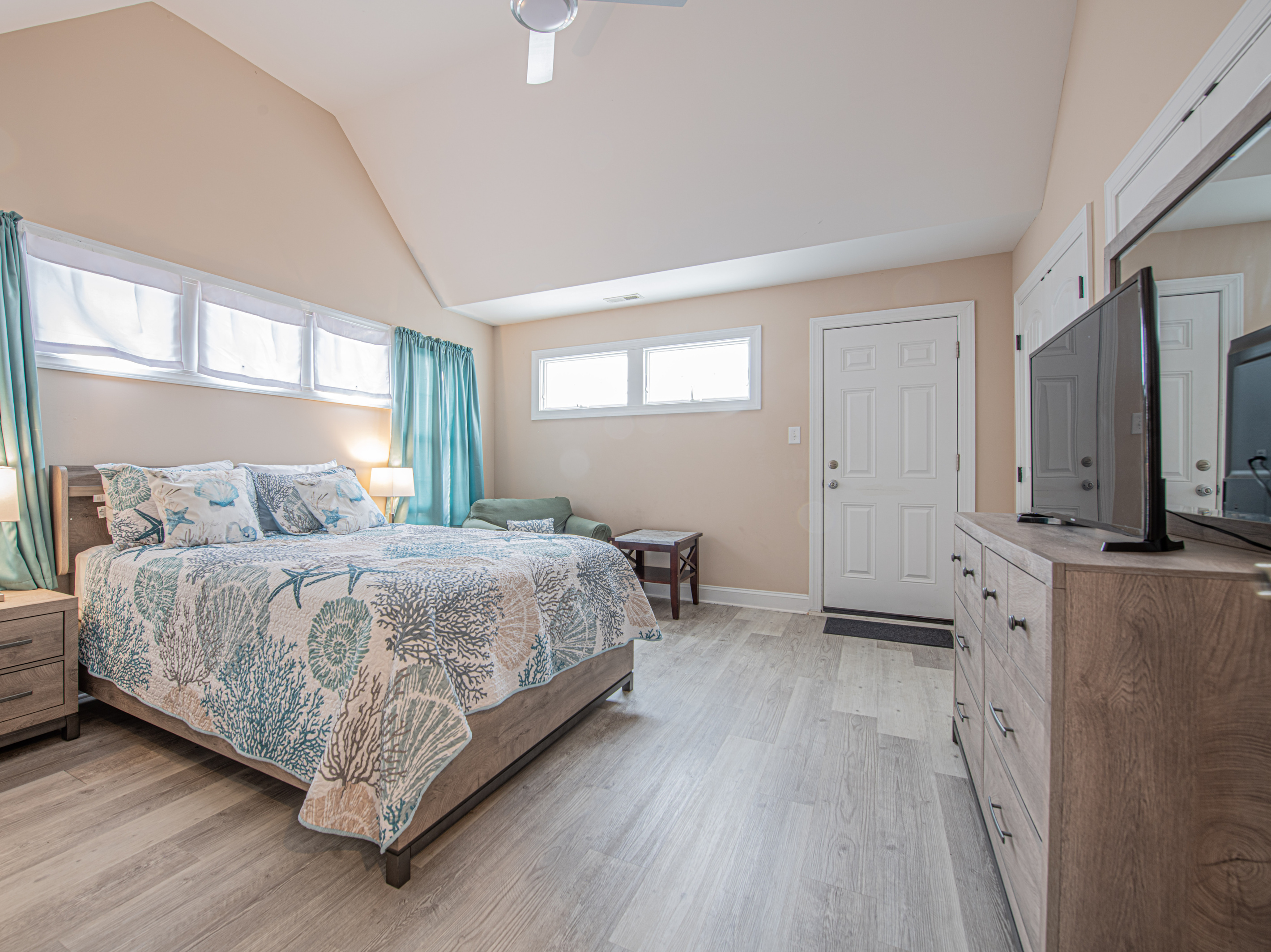 Bedroom 1 with Coastal Decor, Dresser, and Vaulted Ceilings