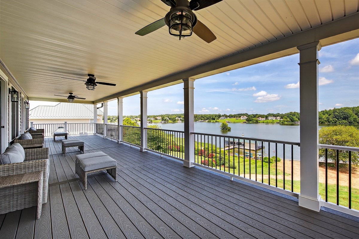 A grand lakefront entertaining space with ceiling fans, ample seating, and uninterrupted water views — the ultimate gathering place.