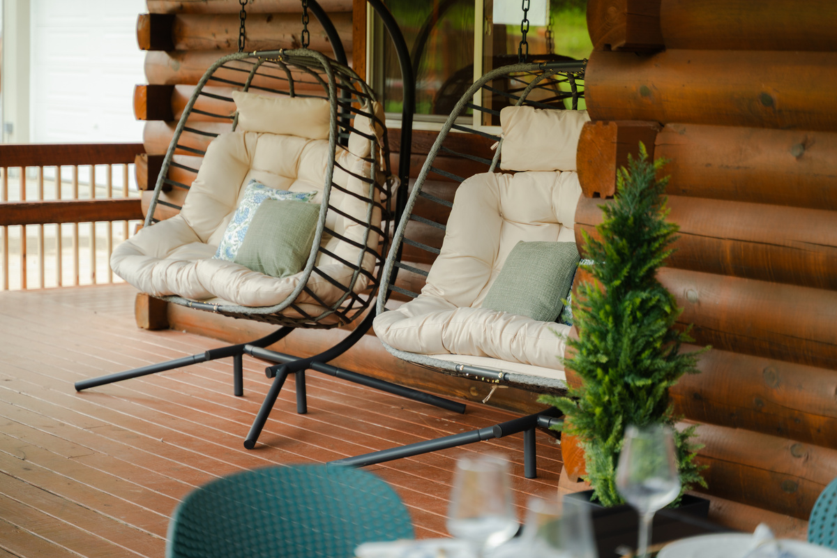 Two double egg chairs offer a cozy spot to relax together and take in the peaceful wooded surroundings.