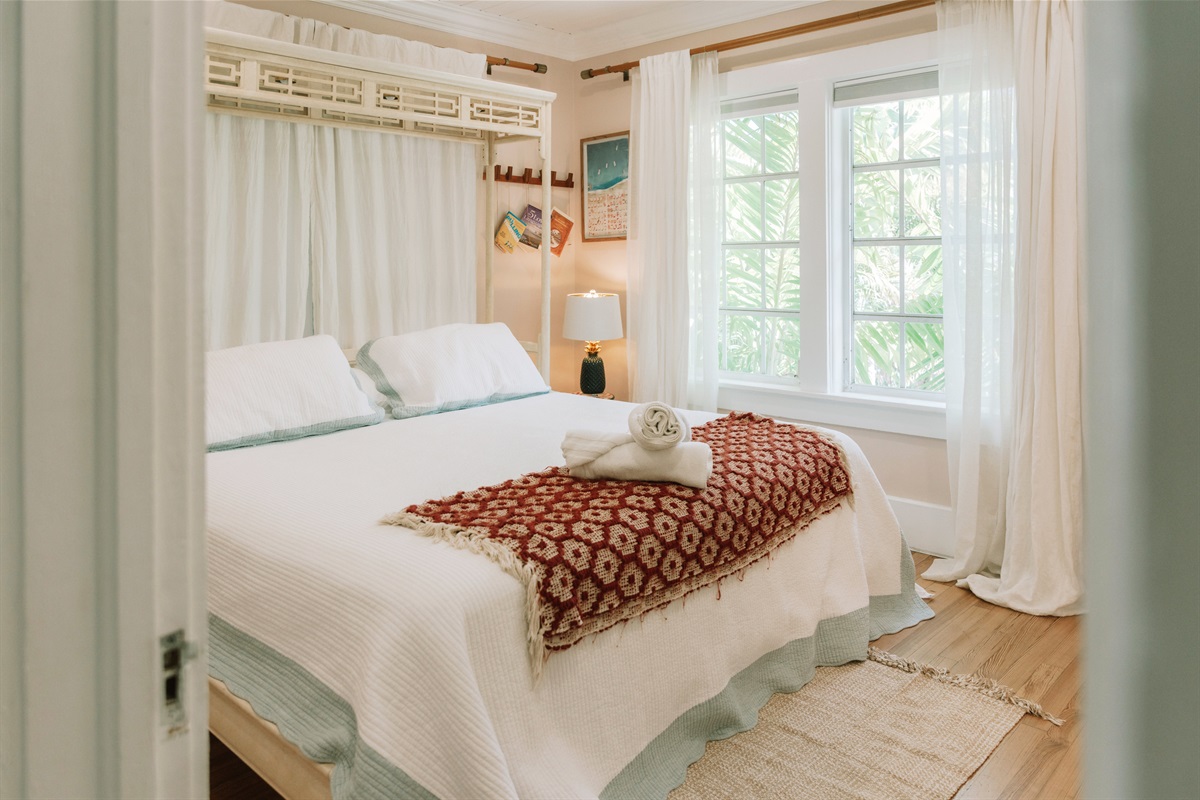 The main bedroom is comfortably furnished, with a pleasant view overlooking the pool.