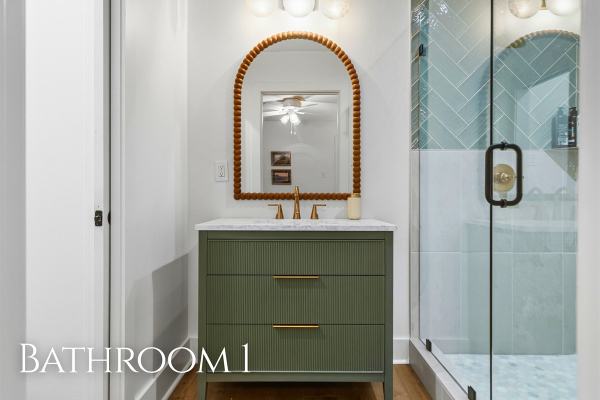 The bathroom features a beautifully tiled walk-in shower and elegant finishes that add a polished, modern touch.