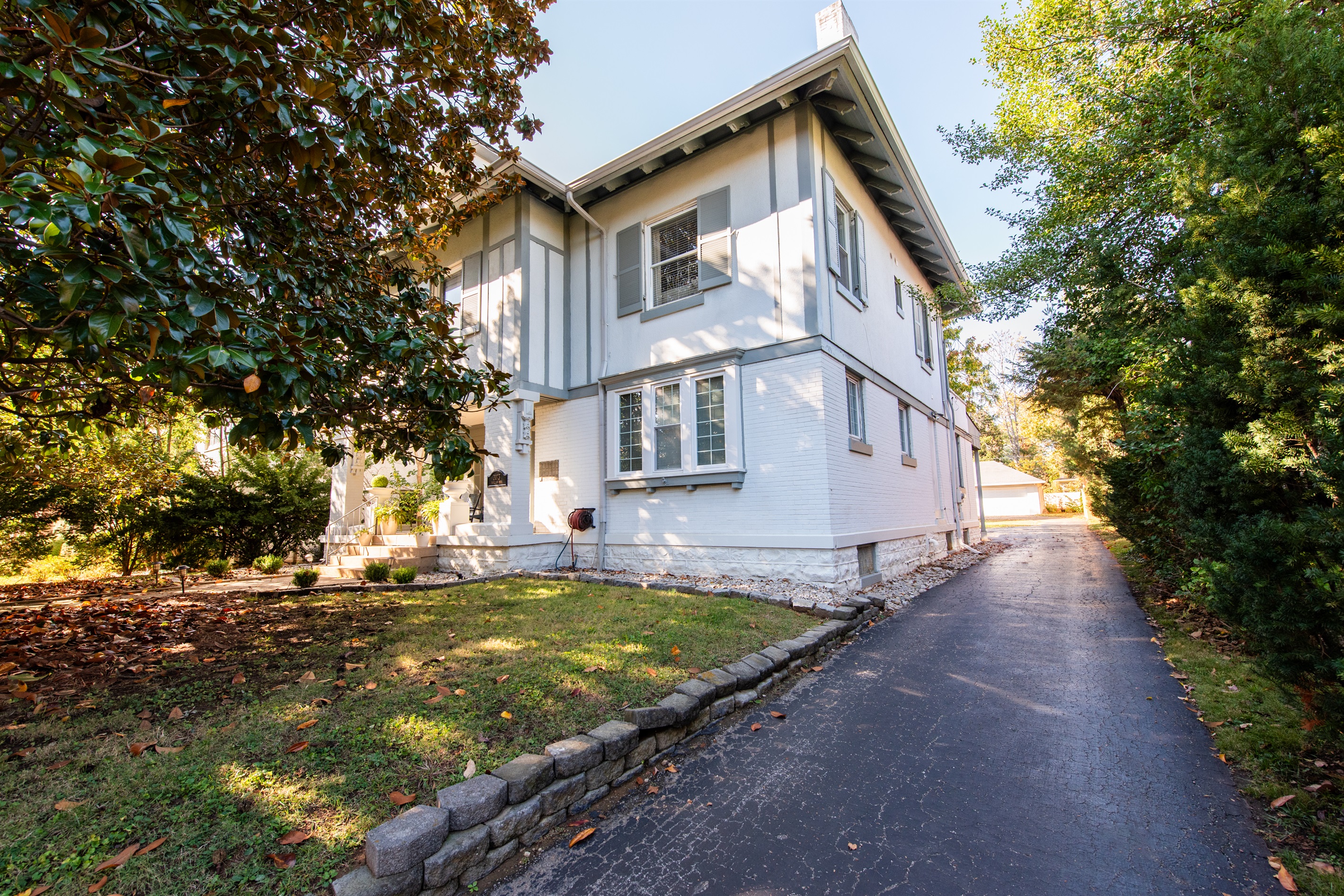 Charming white house on 1/2-acre in Louisville Highlands, KY Bourbon Trail. Private driveway with parking for 12 cars, lush lawn, stone wall—perfect for a serene getaway!