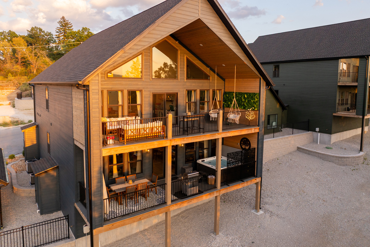 A first look at Enchanted Landing—a brand-new hillside retreat featuring soaring windows, two spacious decks, outdoor living and dining areas, and a private covered hot tub.