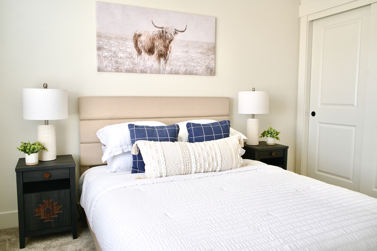 Second bedroom upstairs, furnished with a queen bed and bedside tables on both sides. This room features spacious closets and is thoughtfully designed with elegant, stylish finishes.