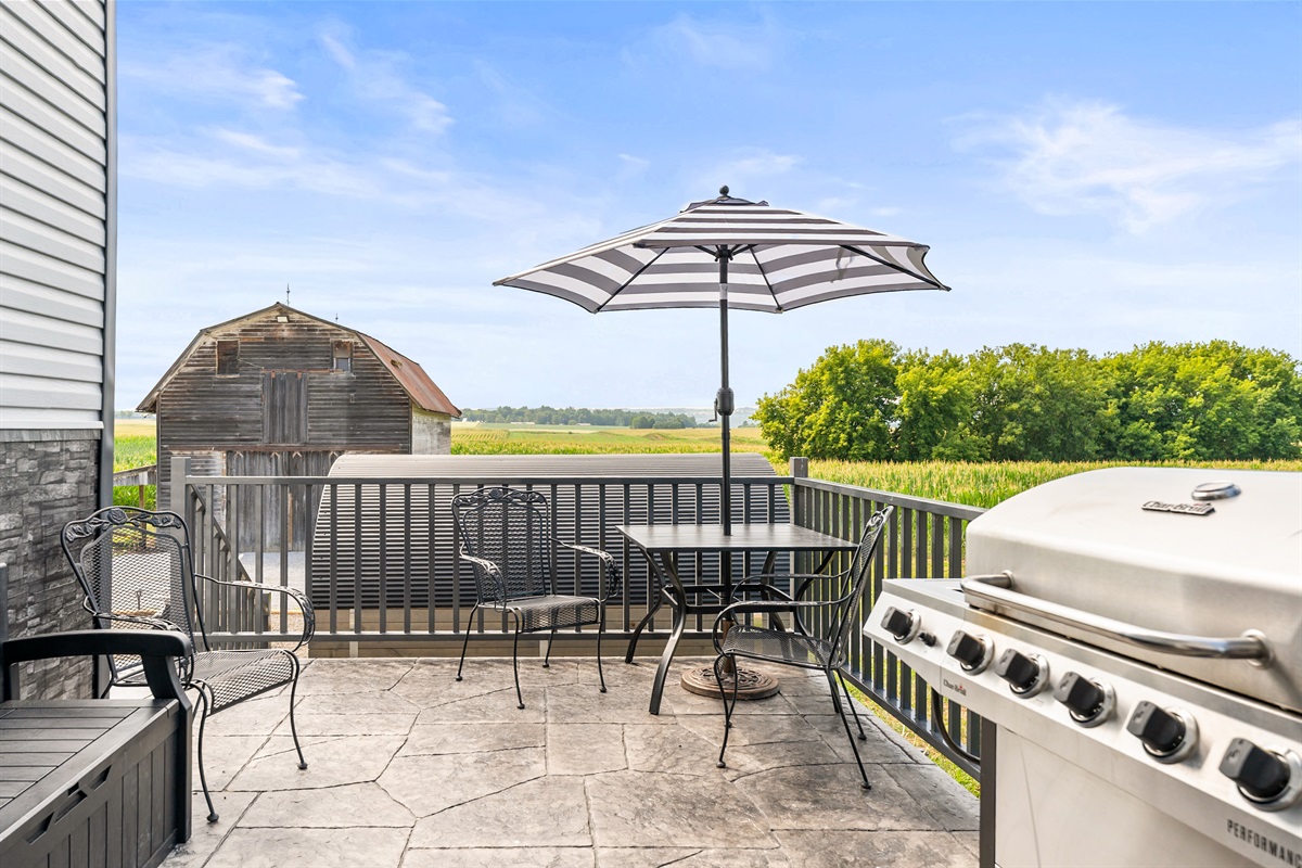 Dine al fresco under the umbrella with peaceful views of the barn and open fields.