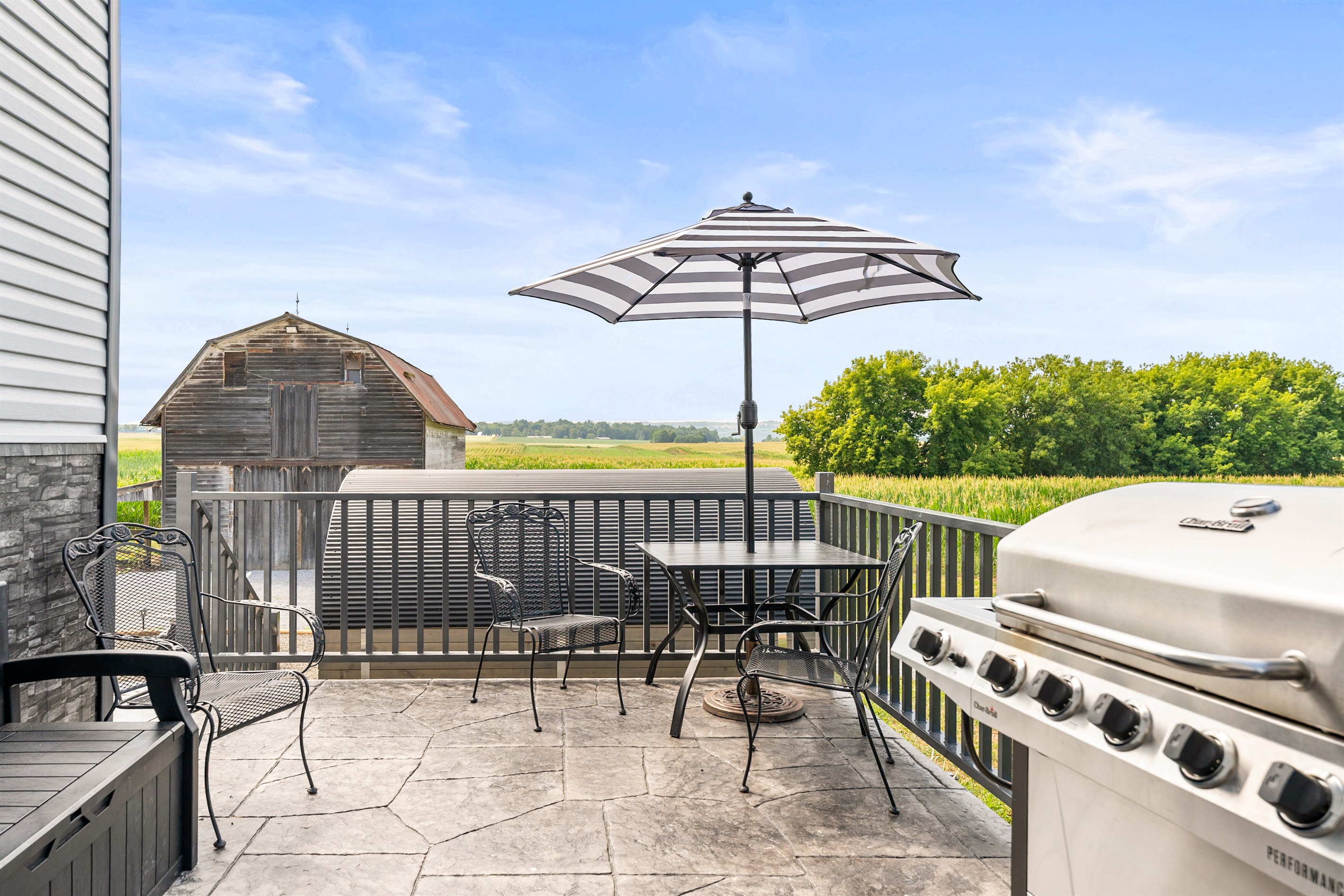 Dine al fresco under the umbrella with peaceful views of the barn and open fields.