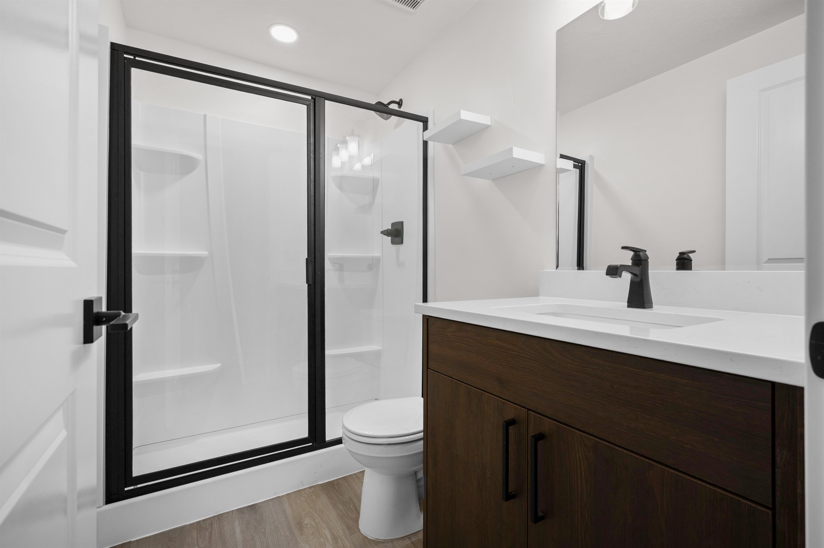 Stylish bathroom with glass-door shower and quartz vanity.